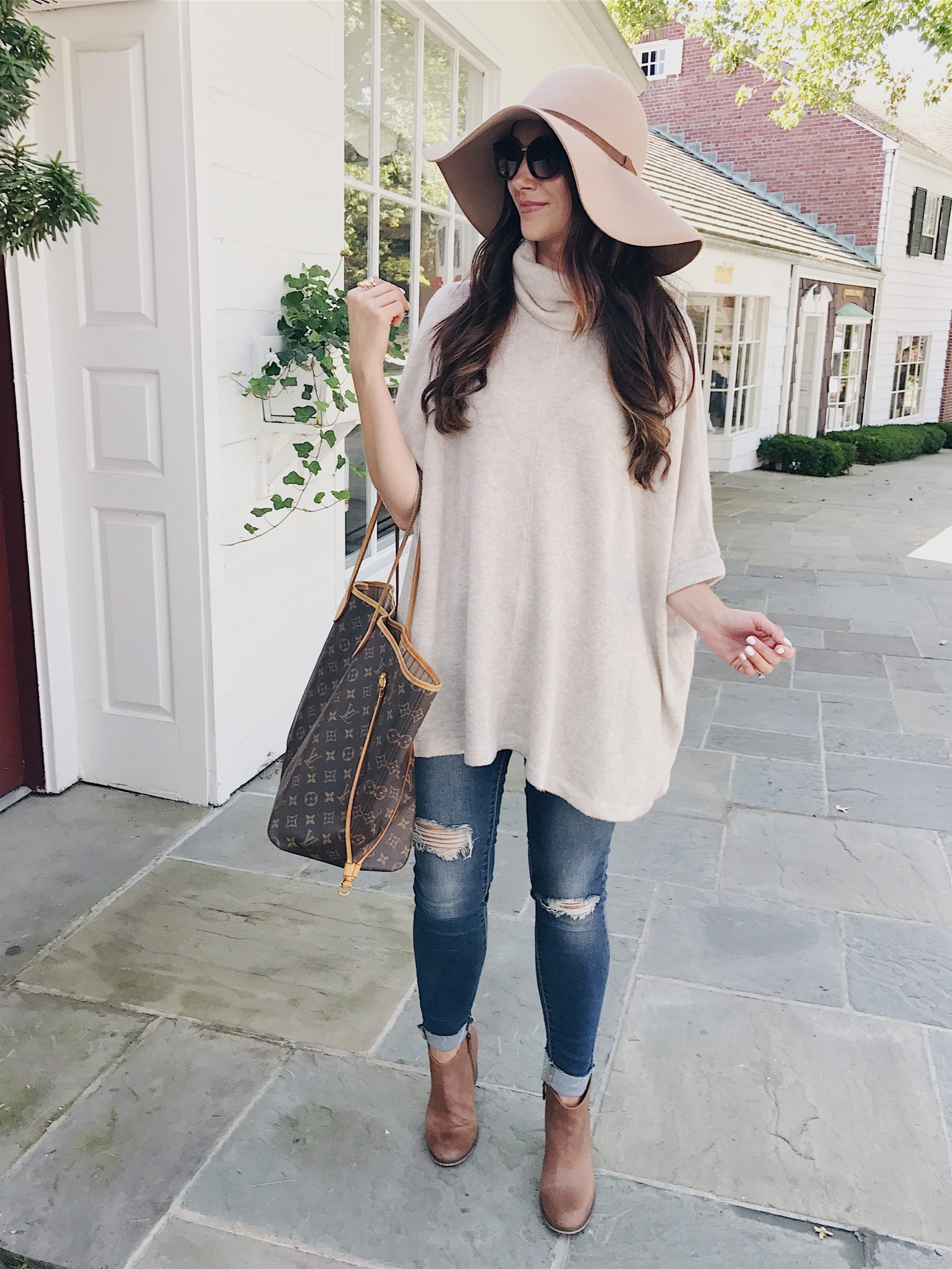 blogger Anna Monteiro of Blushing Rose Style wearing fall outfit floppy hat, brown booties and sweater poncho.