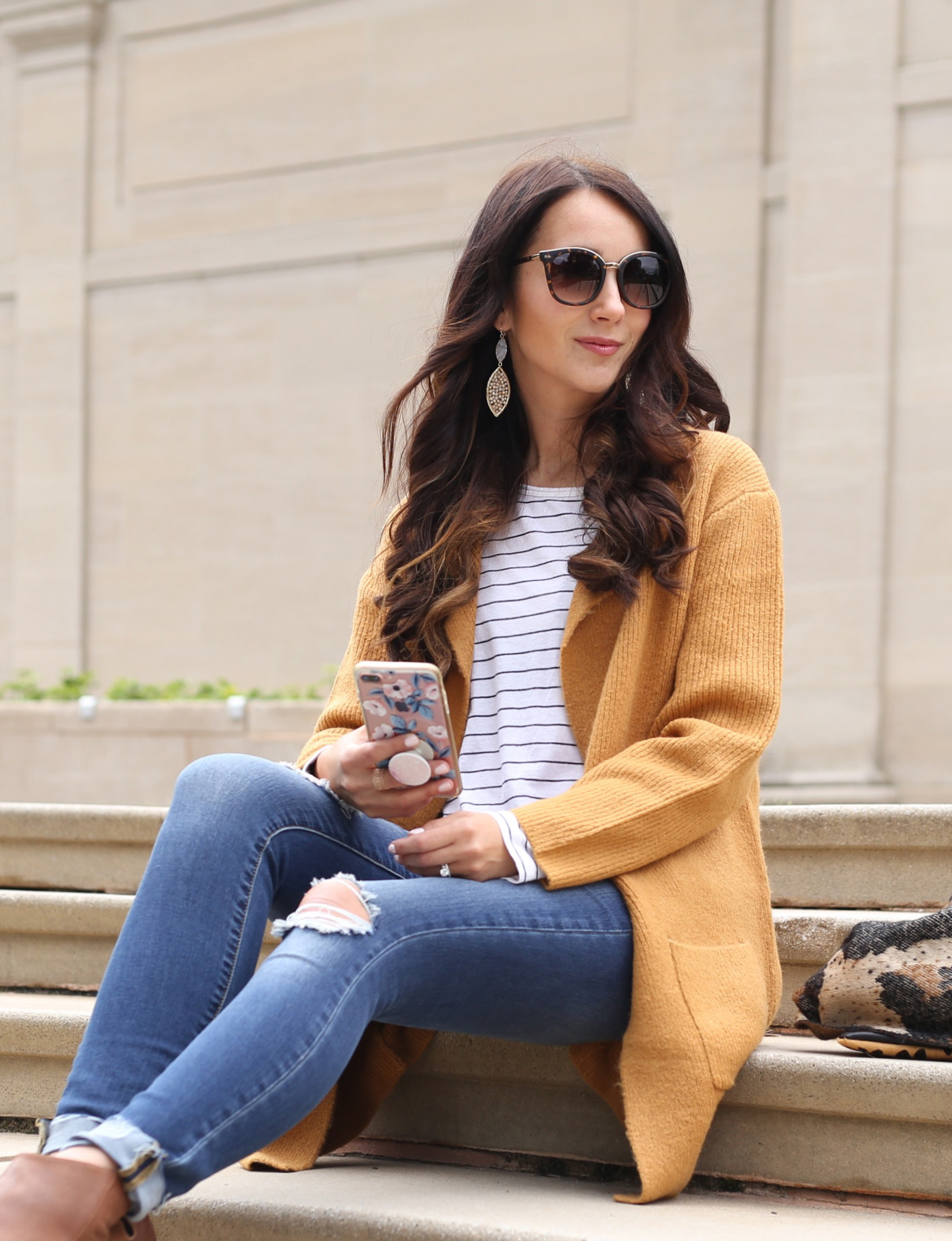 blogger Anna Monteiro wearing cozy fall sweaters with striped tee and leopard print scarf