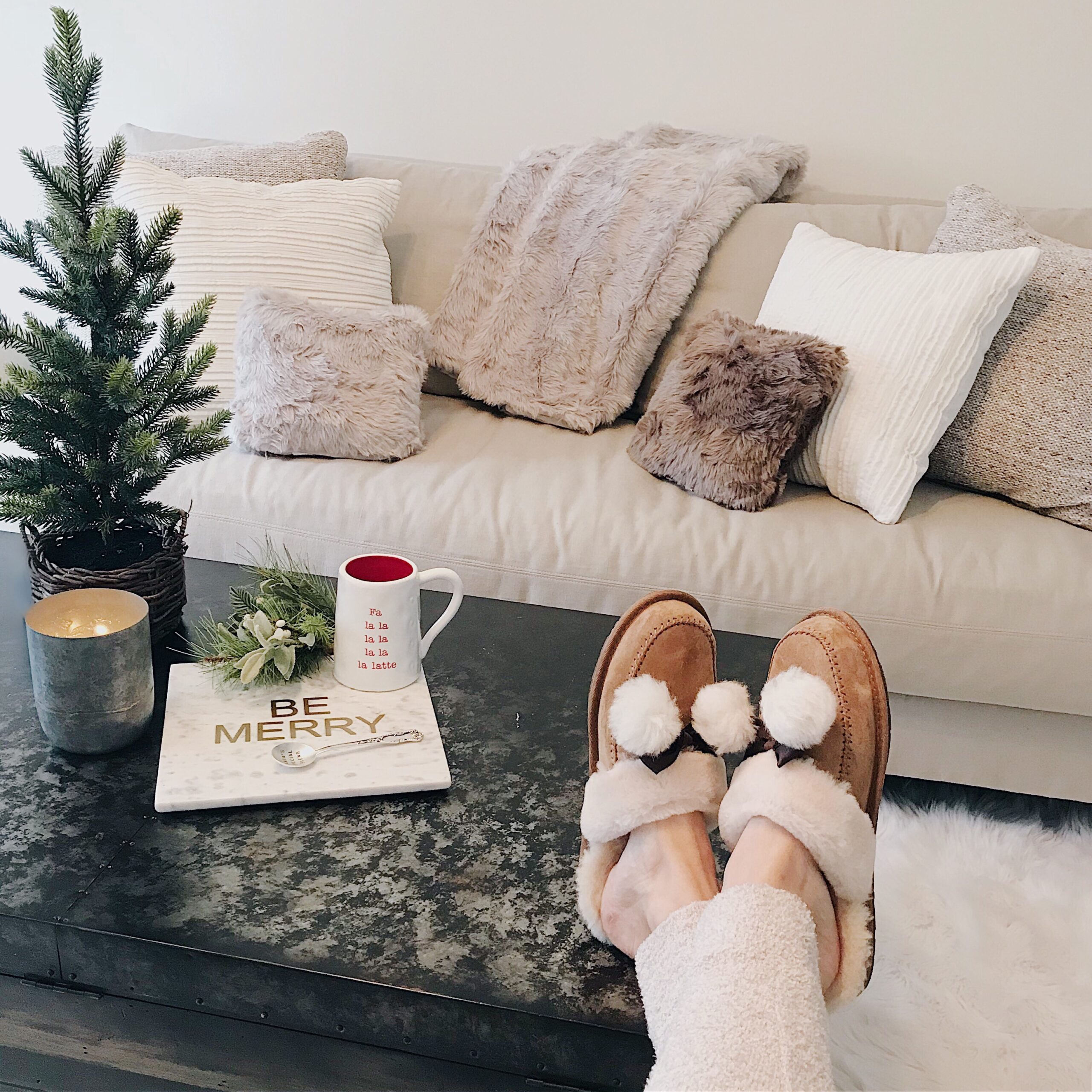 cozy holiday home decor faux fur pillows white couch and ugg slippers