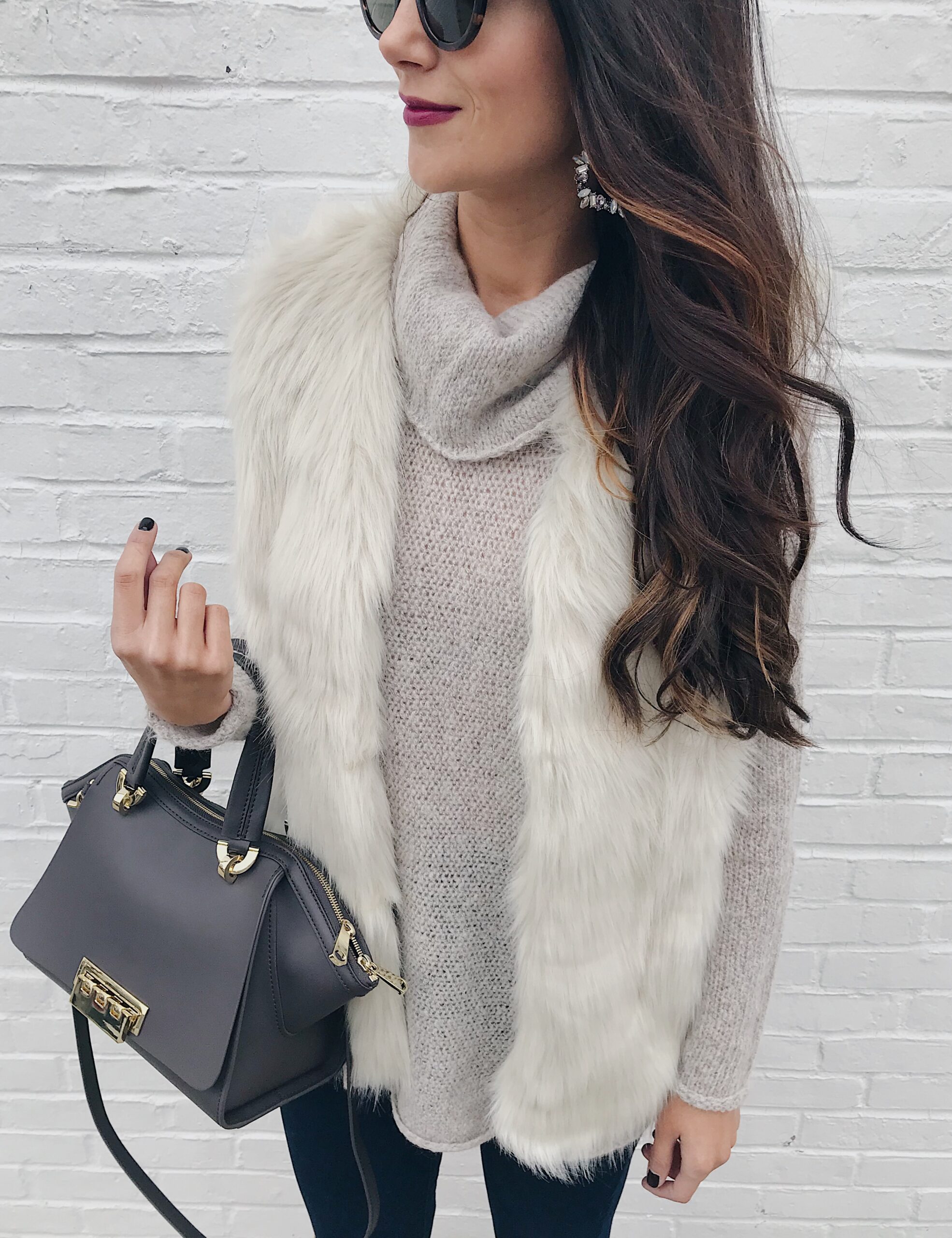 anna monteiro of blushing rose style blog wearing faux fur vest, and tunic sweater in 3 must have boot styles to own this season