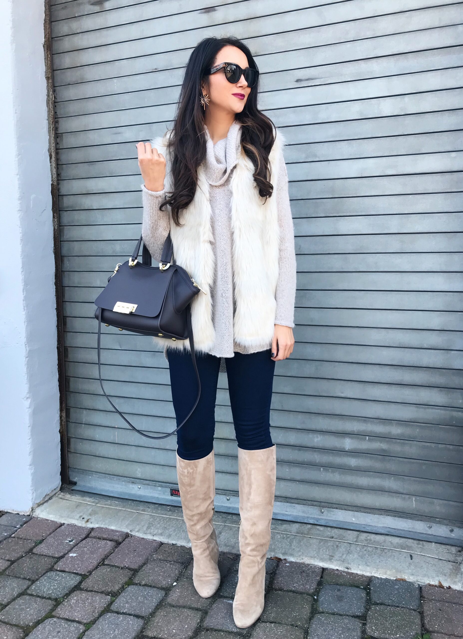 anna monteiro of blushing rose style wearing knee high boots and faux fur vest in 3 must have boot styles to own this season