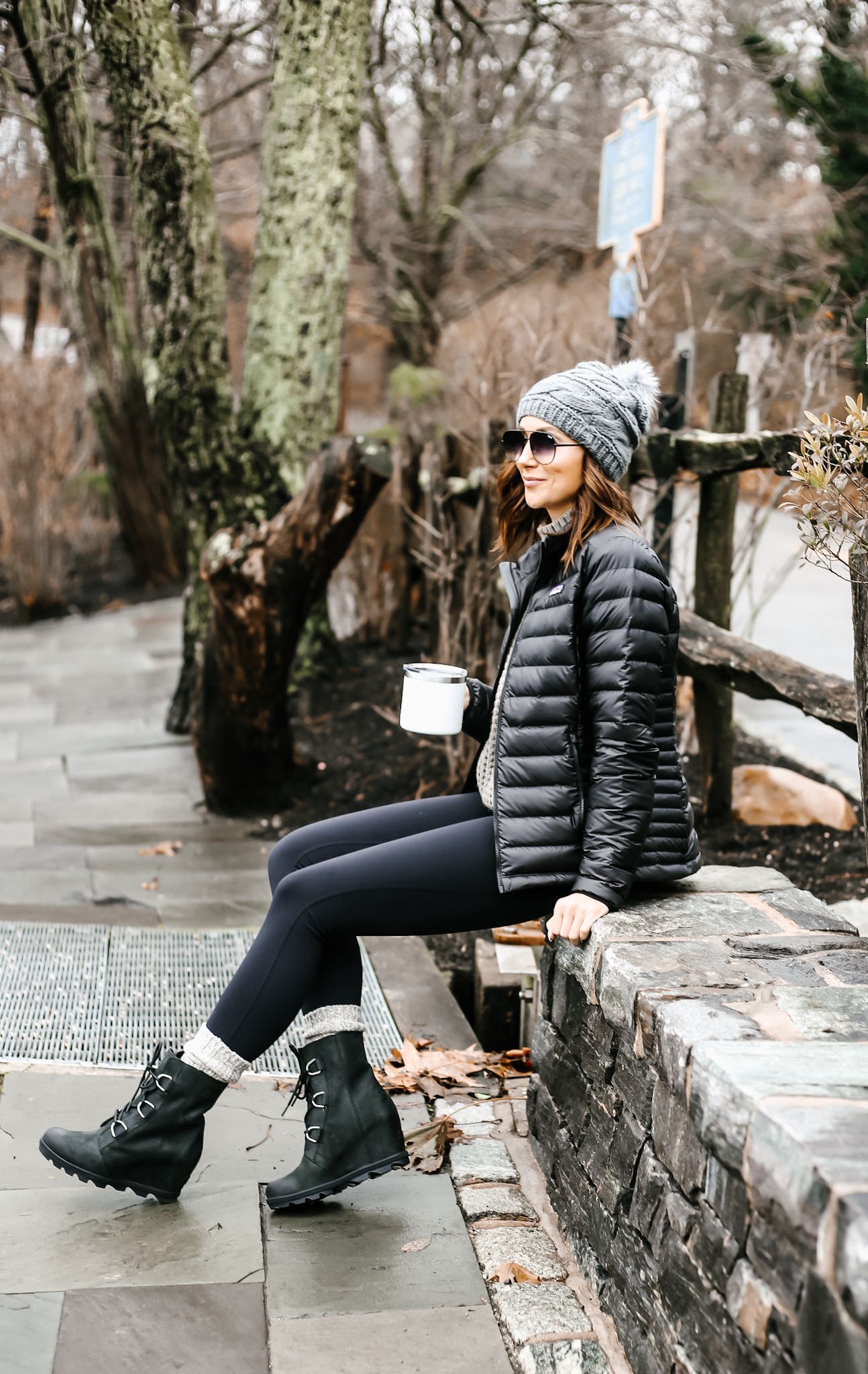 women sitting in the park, in warm leggings, sorel joan of arctic boots and patagonia jacket