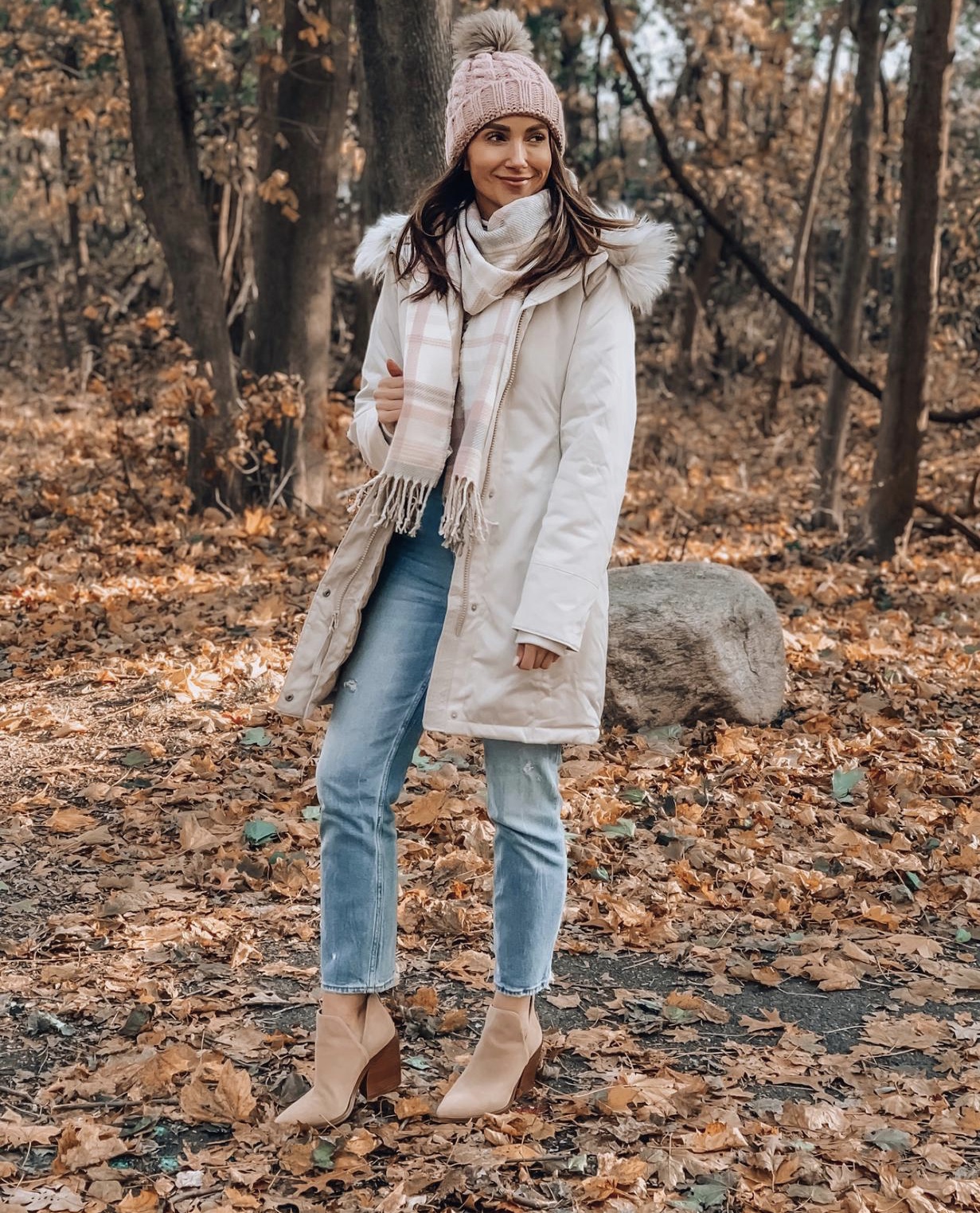 Woman wearing down jacket, jeans and booties