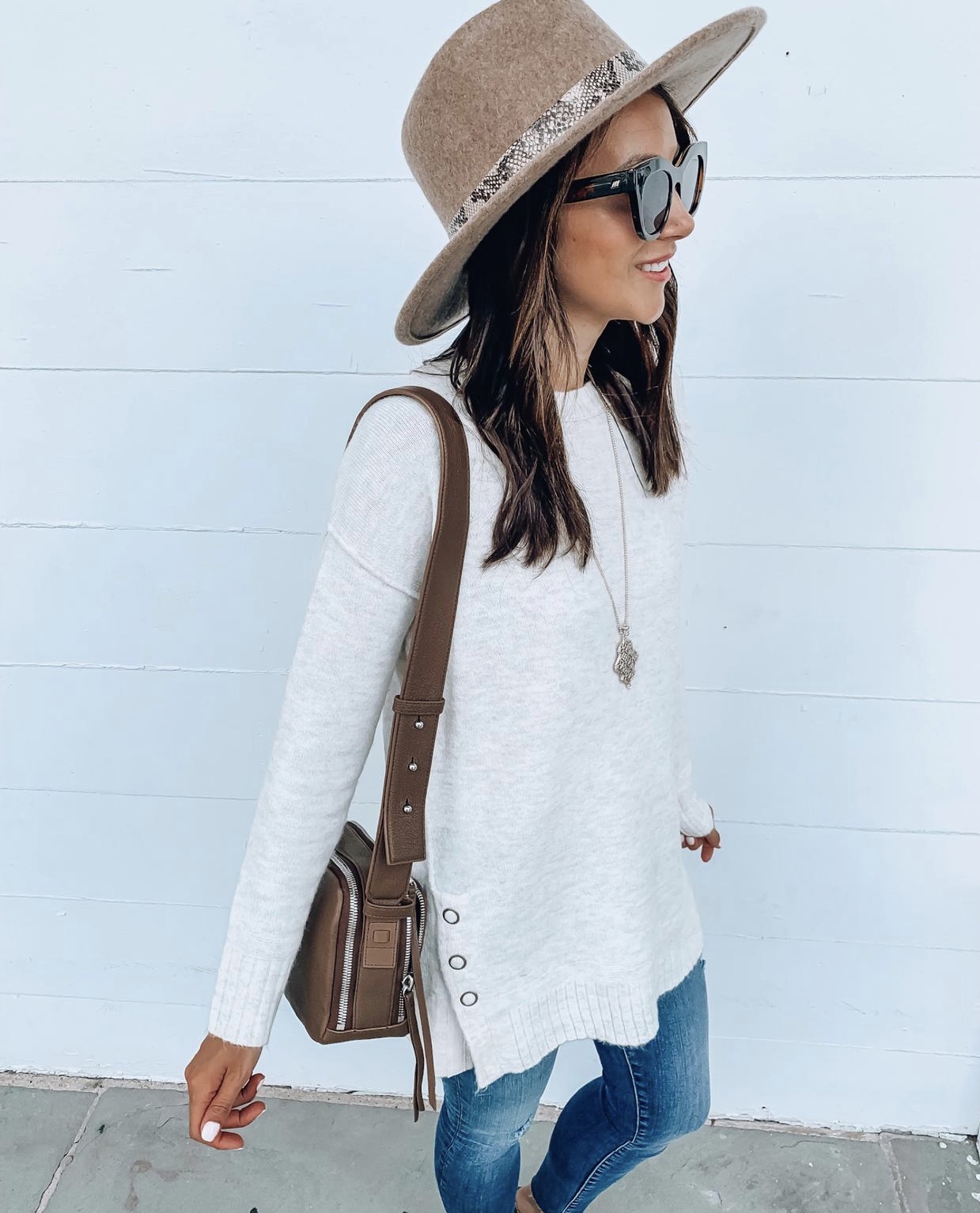 Woman wearing sweater tunic, hat, jeans