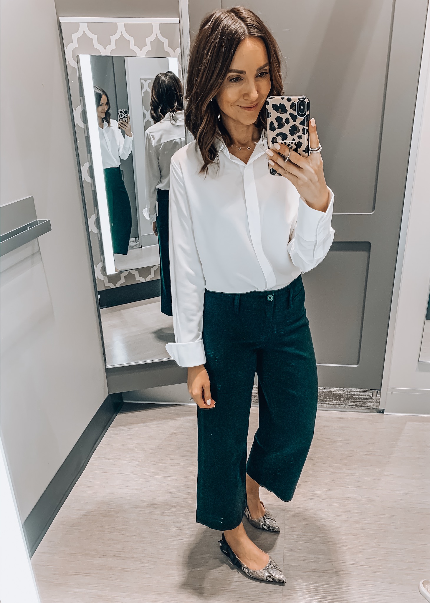 woman wearing workwear style, white blouse, black wide leg pants