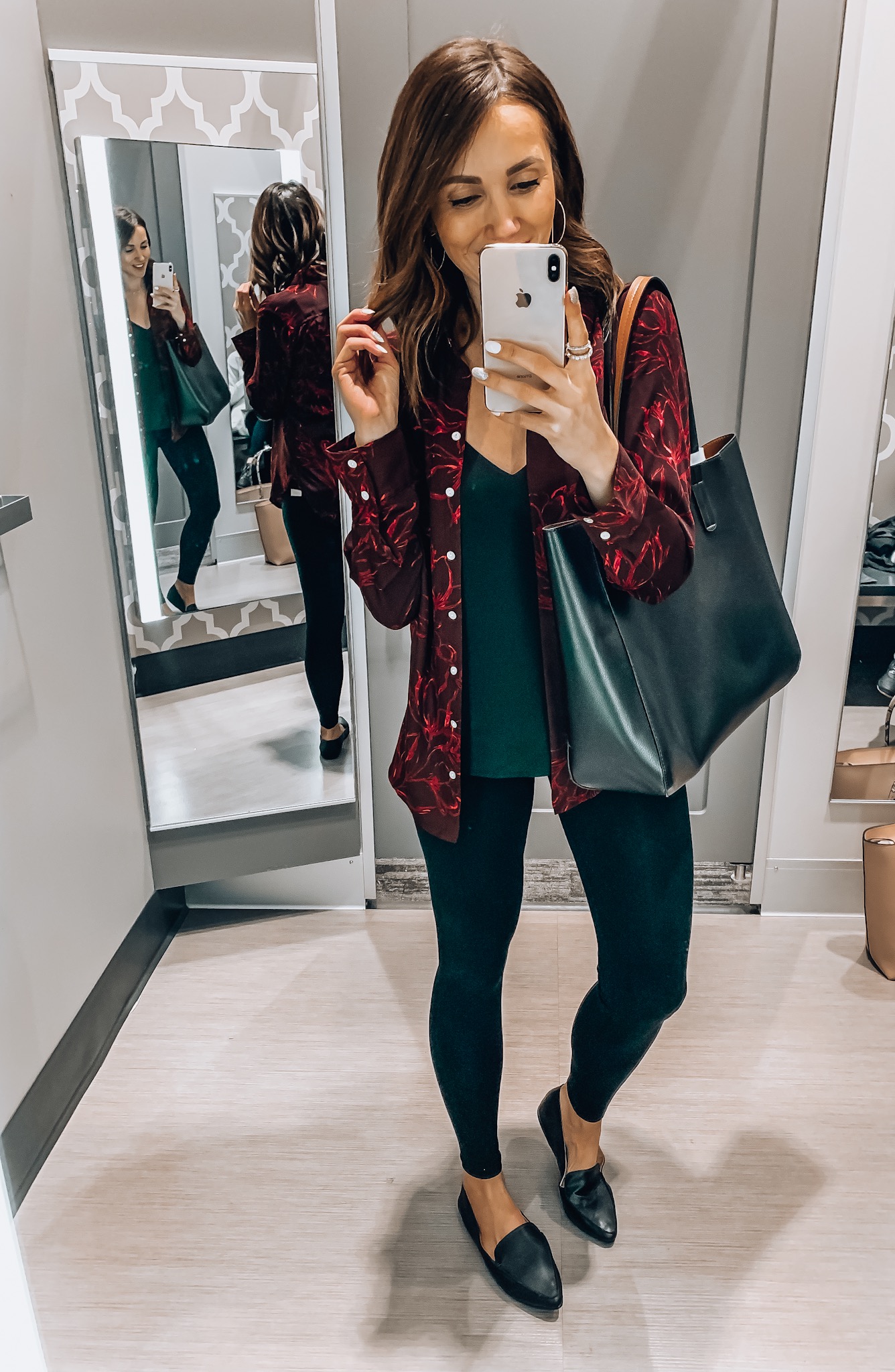 woman wearing floral blouse, skinny jeans, tote bag