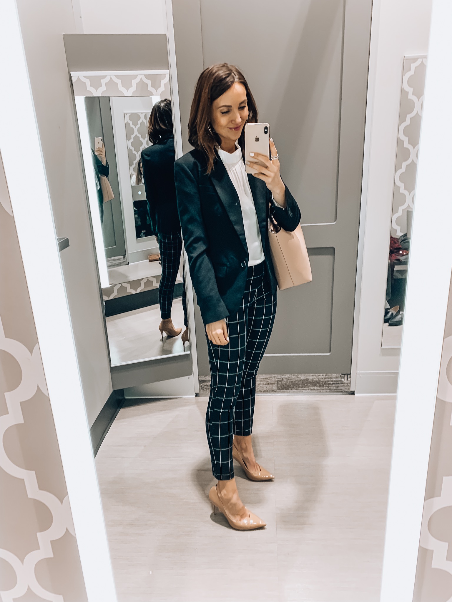 Woman wearing blazer, window pane print pants, white blouse, workwear style