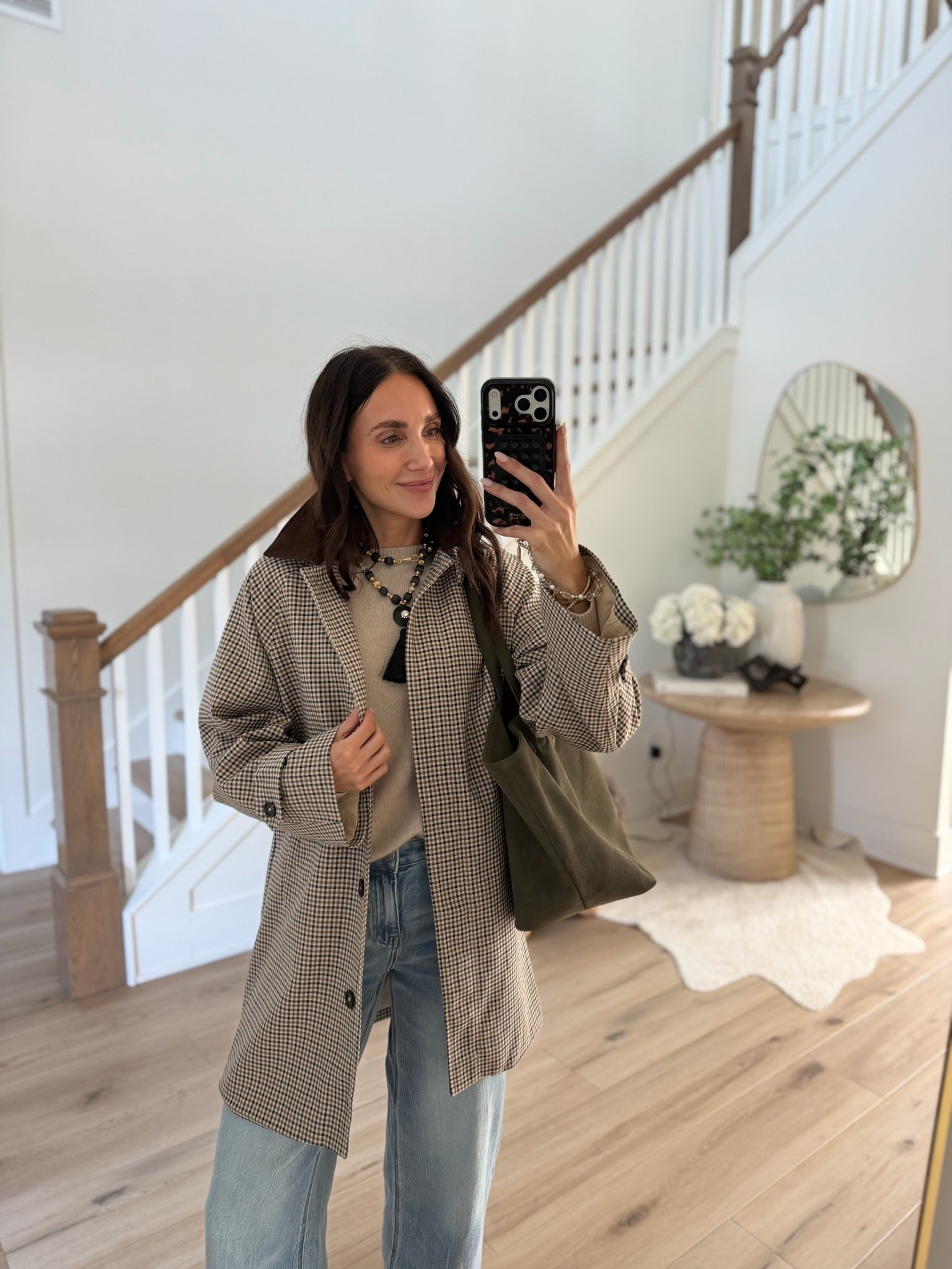 Anna of Blushing Rose Style wearing an oversized plaid blazer, neutral sweater, light wash jeans, and olive green tote bag for a casual fall outfit.