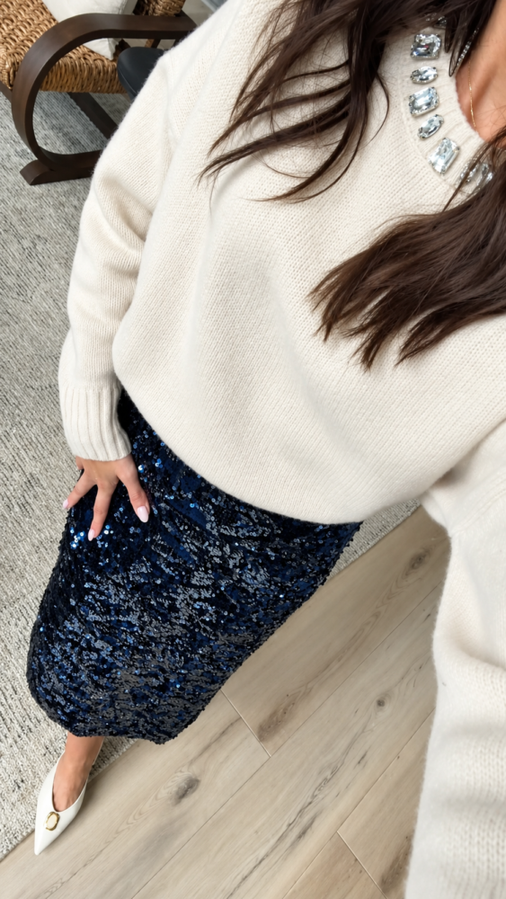 Cream embellished sweater paired with a navy blue sequin skirt for a dressy Christmas party or holiday dinner outfit.